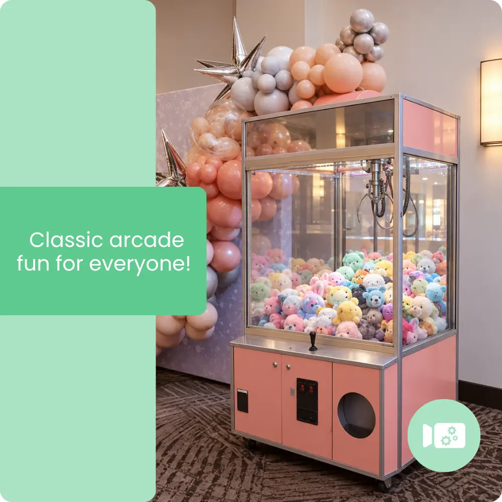 Pink claw machine rental filled with colorful stuffed animals at a party